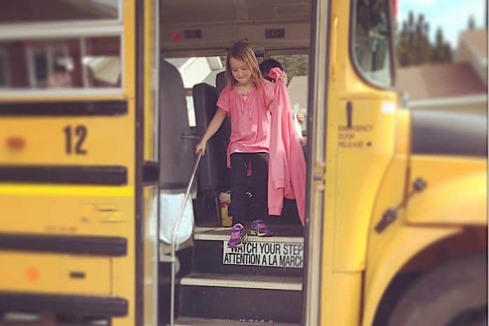 Stock photo of student exiting her school bus.