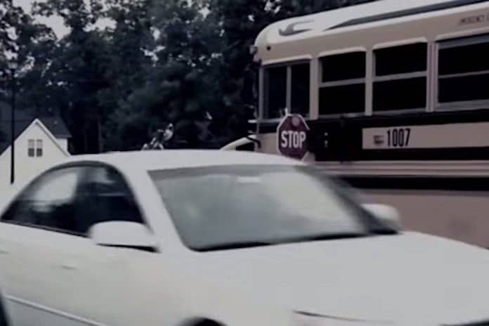 Photo depicts a motorist illegally passing a stopped school bus.