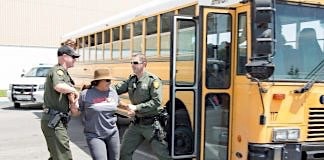 Police arrest parent trying to board school bus.