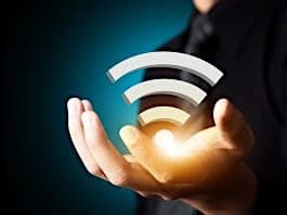 Hand holding a Wi-Fi signal of strength.