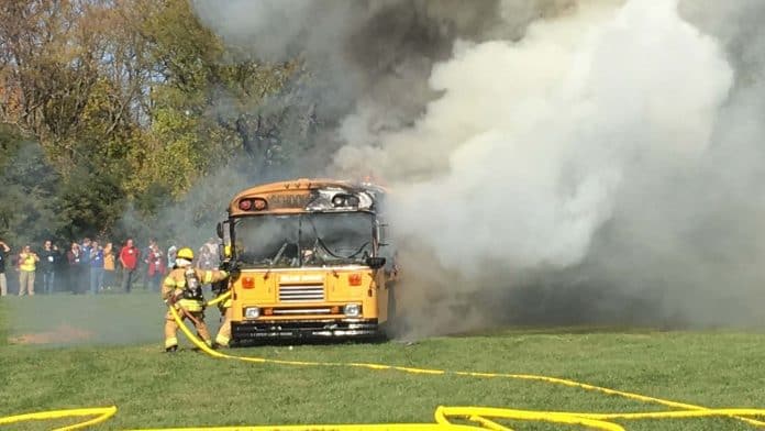 Firefighters put out a controlled blaze during a school bus safety training exercise.