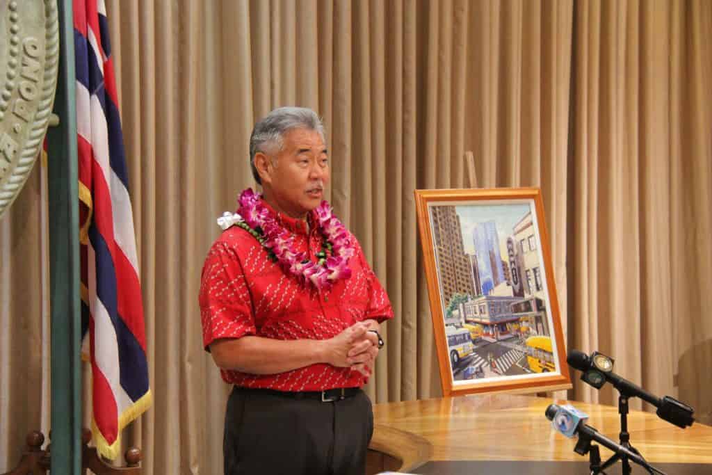 Gov. Ige explains school bus poster artwork.