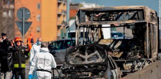 Forensic policemen and firefighters work by the wreckage of a school bus that was transporting 51 children on March 20, 2019, after it was torched by the bus’ driver, in San Donato Milanese, southeast of Milan. (Photo courtesy of CNN.)