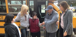 School bus driver Gary Wozniak of Koch Bus hands a student a “Success Ticket” as part of a Positive Behavior and Intervention Supports program used for student transportation at Intermediate District 287 near Minneapolis. Also pictured, (left) is Laury Force, a job coach at Ann Bremeer Education Center, and (far right), Transportation Manager Amy Tiedens.