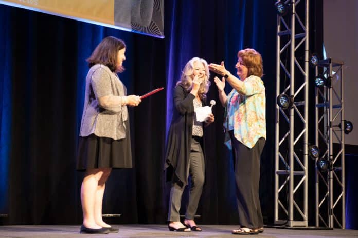 Sue Shutrump, far right, receives the 2018 Grandolfo Award from Q'STRAINT's Lisa Nippolt, center, and Linda Grandolfo.
