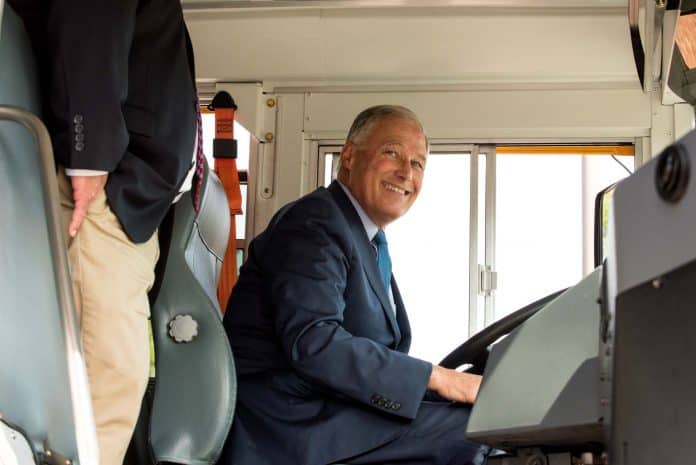 Gov. Jay Inslee sits in the new all-electric Blue Bird school bus.
