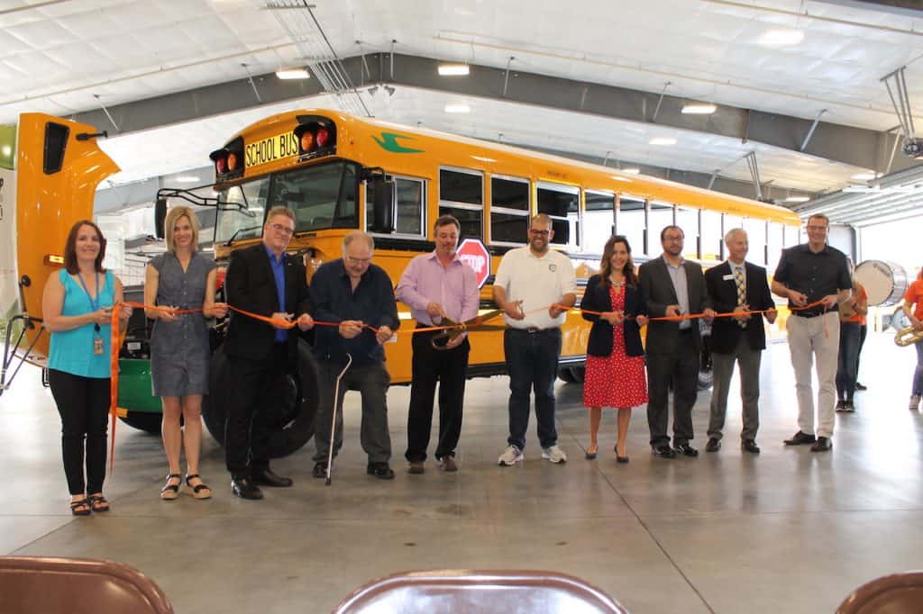 Ribbon cutting in front of a new e16 Blue Bird electric school bus