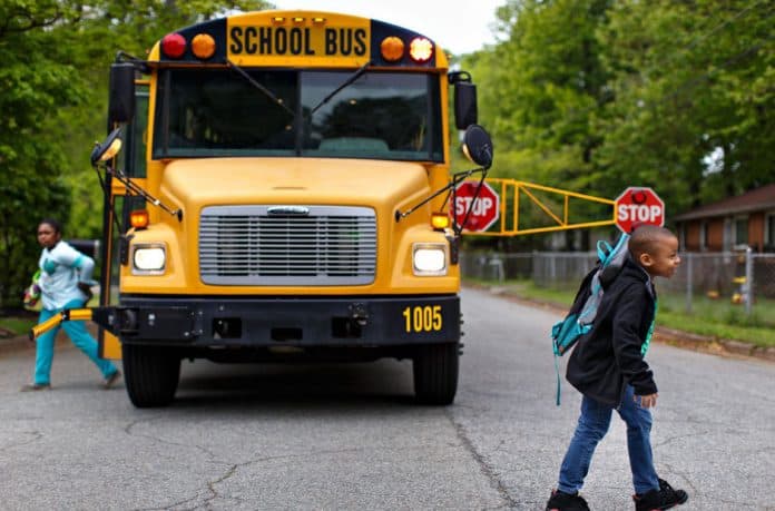 School bus using the extended stop arm with children present