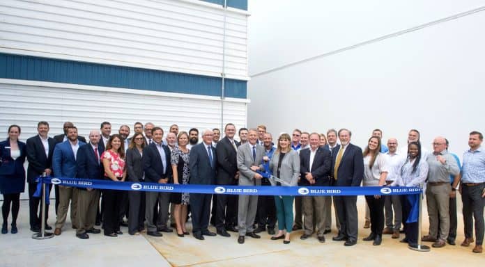 Blue Bird employees at the new paint facility in Fort Valley, Georgia, are joined by Mollie Blagg, president of the Dealer Advisory Council.