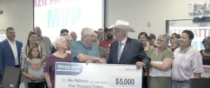 Ken Patterson received a check from Bob Funk at Express Employment of Oklahoma, in recognition of his 20 years of school bus driving. (Photo courtesy of Oklahoma's News 4.)