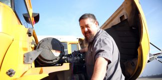 Ray Manolo works on a school bus. He discussed green bus maintenance at a summit on April 22, 2021. (Image courtesy of Twin Rivers Unified School District.)