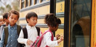 Elementary school kids climbing on to a school bus