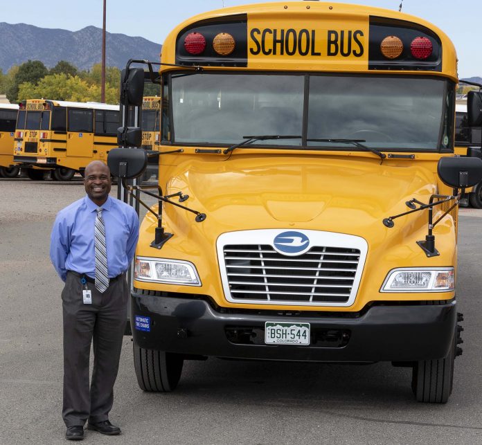 Greg Greg Jackson, director of transportation and fleet services at Jefferson County Schools, poses with a Blue Bird school bus. (Photo by Taylor Hannon.)