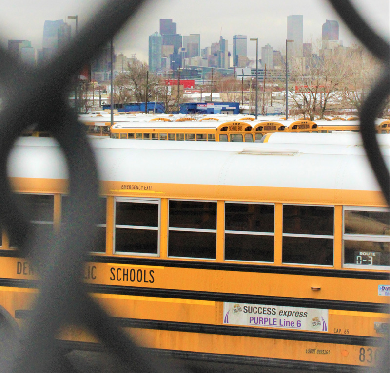 Denver Public Schools' purple Success Express parks at the Hilltop Terminal on Dec. 5, 2019, with the city skyline on the horizon. 