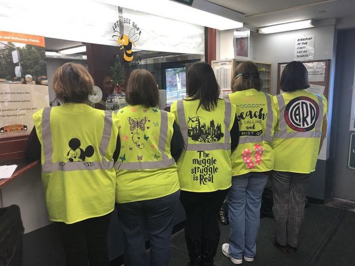 Transportation staff at Brewster Central School District pose with their newly decorate safety vests. The vests are improving department morale and encouraging conversations between transportation staff and the student riders.