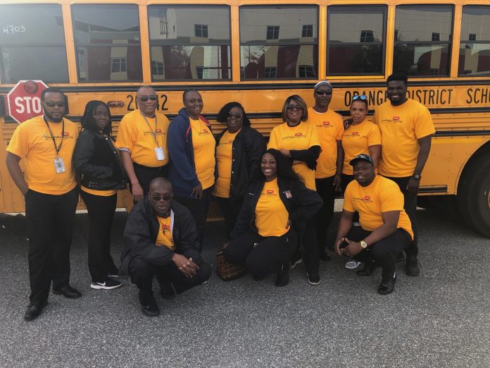 Transportation staff members at Orange County Public Schools in Florida pose with a school bus during the Love the Bus event on Tuesday, Feb. 4, 2020. The event is hosted by the American School Bus Council every year. (Photo courtesy of Kim Frye.)