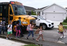 Children crossing street from school bus stop.