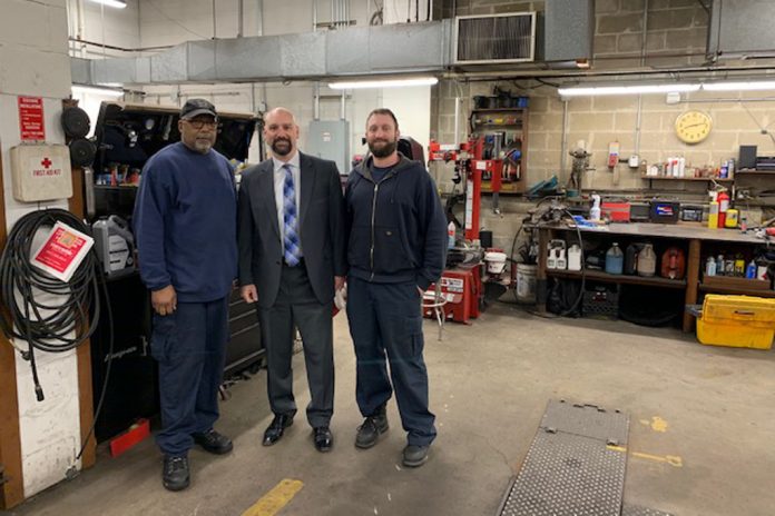 Mineola Public Schools Superintendent Michael Nagler, center, meets with school bus mechanics Greg Glover, left, and Greg Sabator right, at the district's garage.