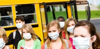 Students leaving a school bus in masks