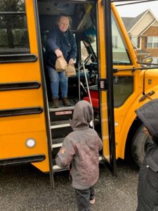 A Gwinnett County Public Schools employee hands out lunch to a child during the Atlanta-area district's coronavirus "Digital Learning Days." (Photo courtesy of Gwinnett County Public Schools.)