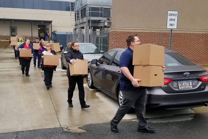 Gwinnett County Public Schools employees carry boxes of food to delivery points for students who are affected by coronavirus closures. (Photo courtesy of Gwinnett County Public Schools)