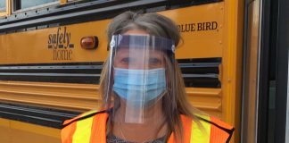 A school bus driver at Diversified Transportation BC wears a face mask and shield, as British Columbia students load and unload the bus. The driver can not where the shield when they are driving. (Photo courtesy of Donna Holmgren.)