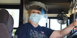 A Fullerton Unified School District bus driver in California, poses with with a face mask and shield.