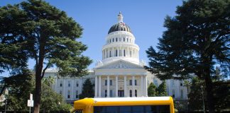 A March 2014 file photo of an early electric school bus parked in front of the state capitol building in Sacramento, California. (Source: Wikimedia Commons/Urvashi Nagrani)