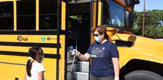 A staff member at Fullerton School District in California checking a child’s temperature prior to them boarding the school bus. (Photo courtesy of Fullerton SD.)