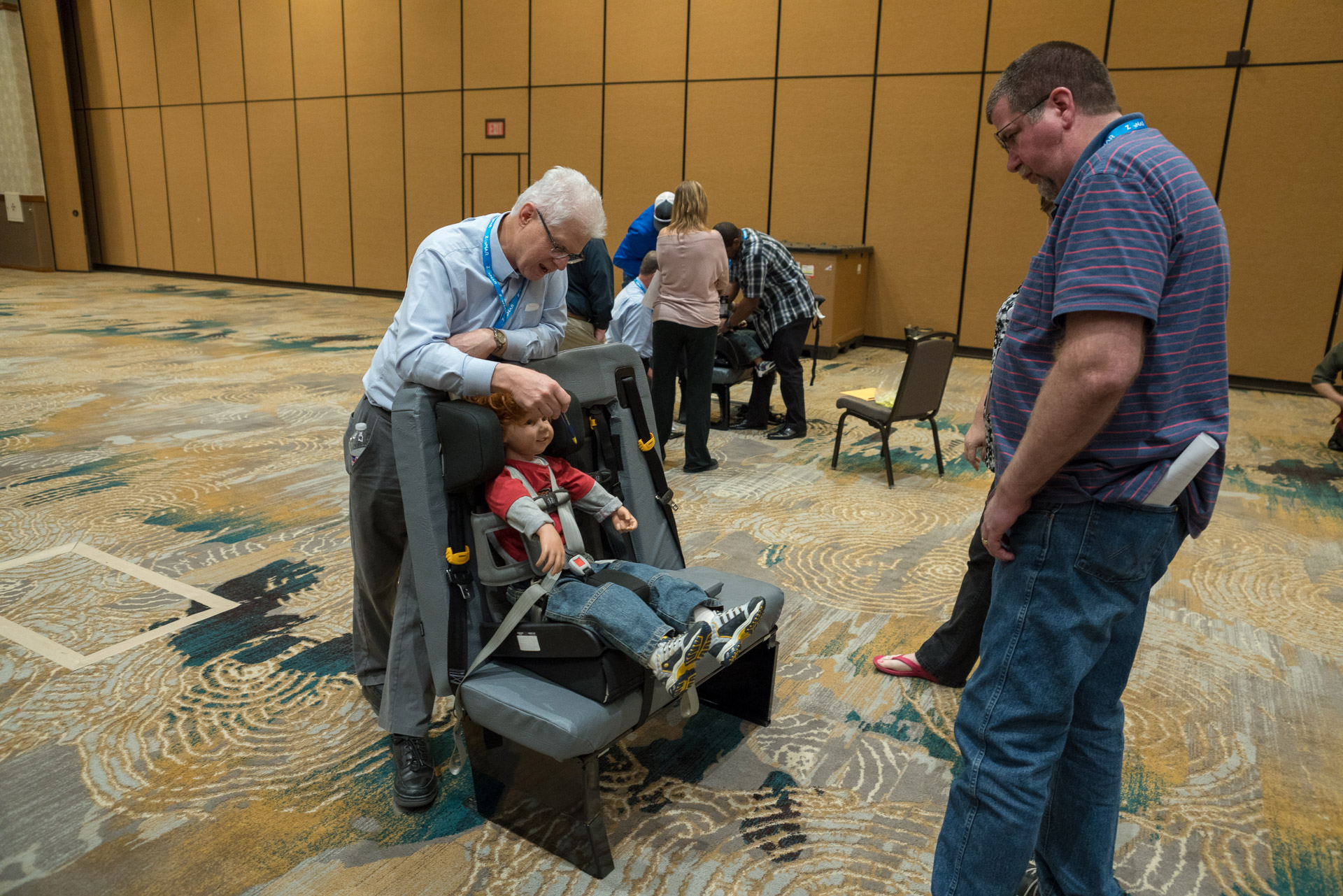 Charles Vits shows attendees of the 2018 TSD Conference the correct procedure for securing a student in a forward-facing car seat on a school bus.