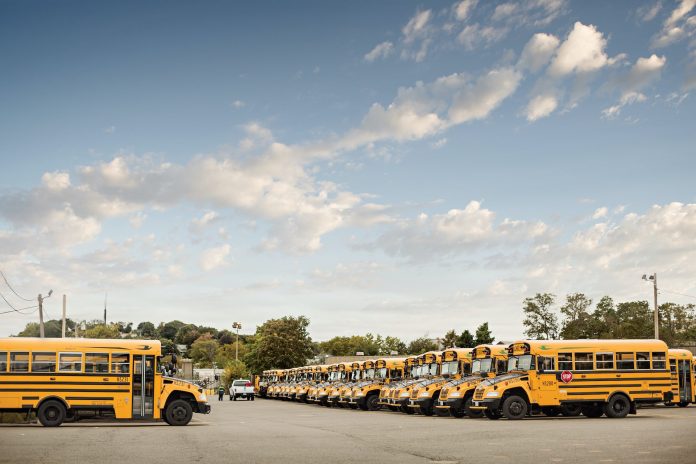 Parked propane school buses at a district transportation facility.