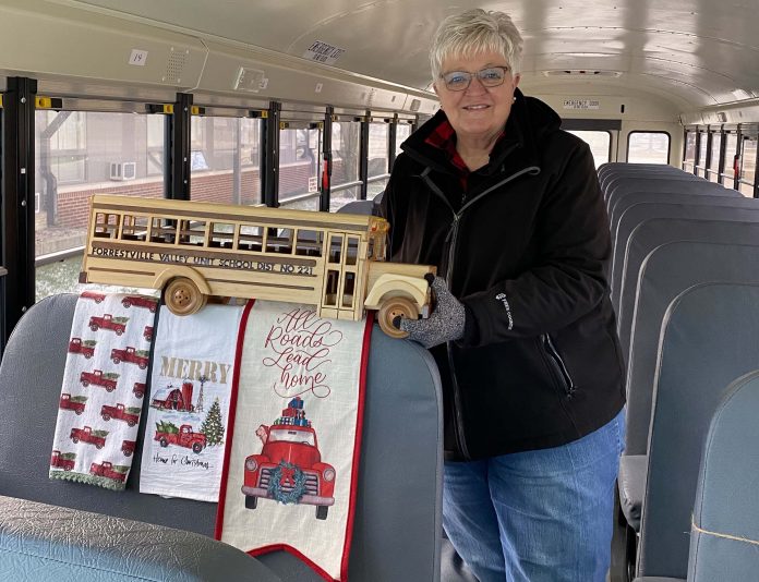 Marsha Birkholz, a school bus driver for, Forrestville Valley CUSD 221 in Illinois, poses with decorations she placed on the seat directly behind her. The seat must remain empty in compliance with COVID-19 guidelines. The theme on Dec. 17 was “All Roads Lead Home to Christmas.”