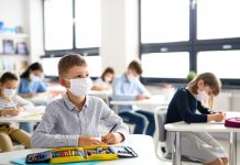 Small children with face mask back at school after covid-19 quarantine and lockdown.