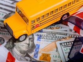 toy yellow school bus , US flag and dollar cash money