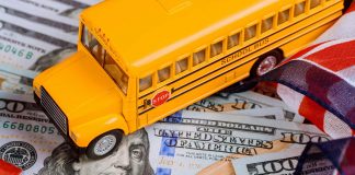 toy yellow school bus , US flag and dollar cash money