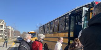 Resident of a long-term care facility board North Kansas City school buses to be transported to a COVID-19 vaccination site.