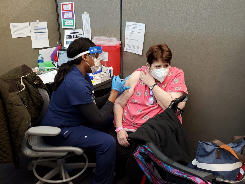 A woman receives a vaccination.