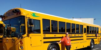 Matthew Thomas, the director of transportation at Anaheim Union High School District in Southern California, poses with a school bus. Thomas is going on 25 years in the industry and recently reinvented himself.