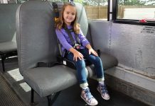 Preschool student sits in a booster seat approved for use in school buses.