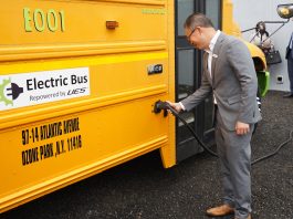 Vic Shao, CEO of AMPLY Power, plugging in the new electric school bus at New York City's ribbon cutting ceremony on June. 3, 2021.