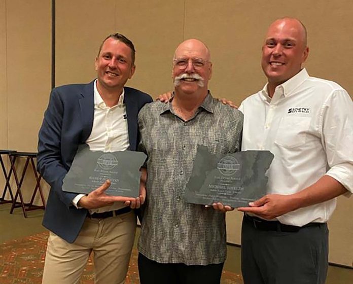 From left: Chase Schetky, co-owner of Schetky NW Bus Sales; Michael Shields, retired Director of Transportation from Salem-Keizer SD; and David Schetky, co-owner of Schetky NW Bus Sales received the 2020 Ron Bryan President's Award during the Oregon Pupil Transportation Association Conference. David and Chase accepted the award for their father, Randy Schetky, who died on April 3, 2020.