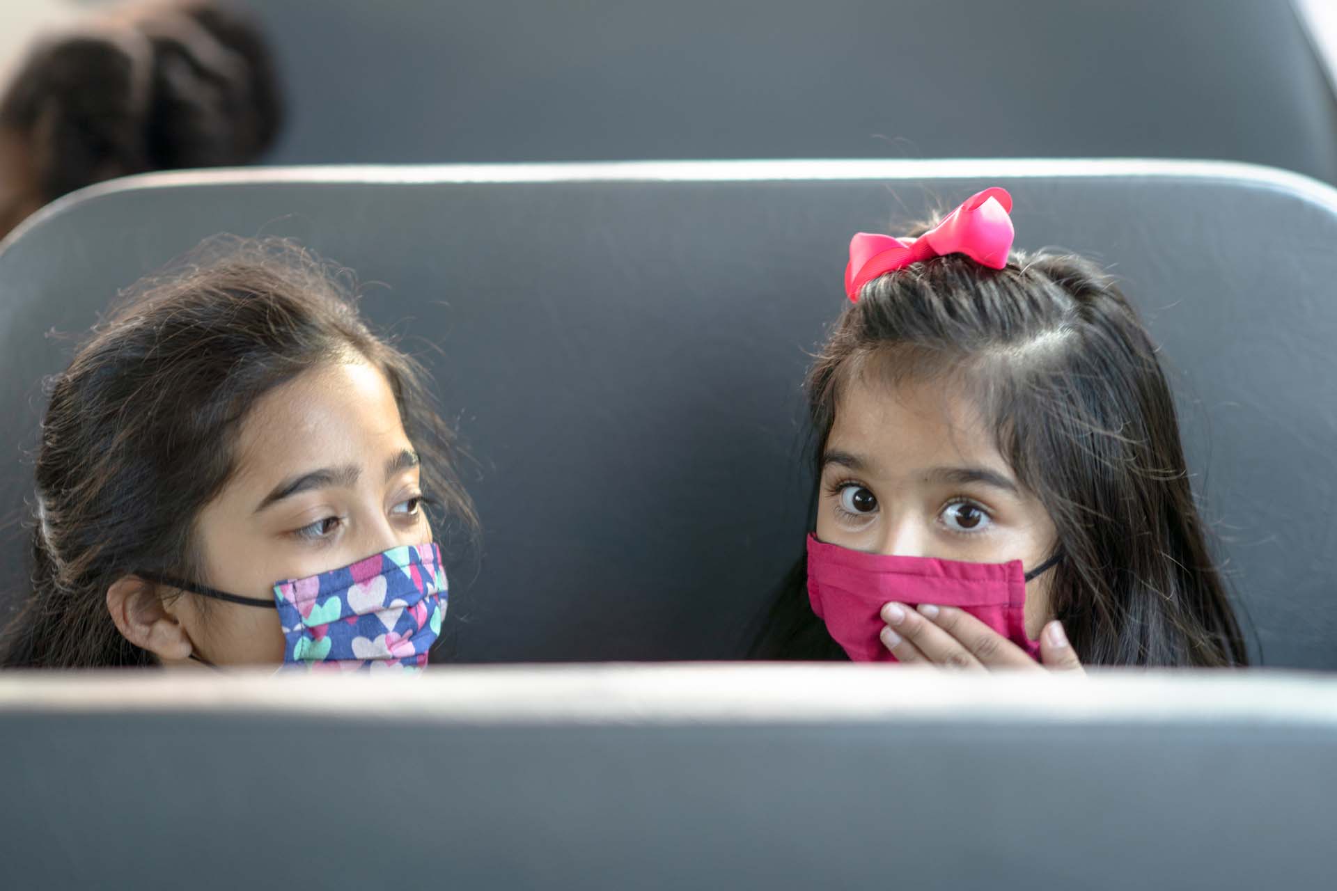 children in bus seat look back