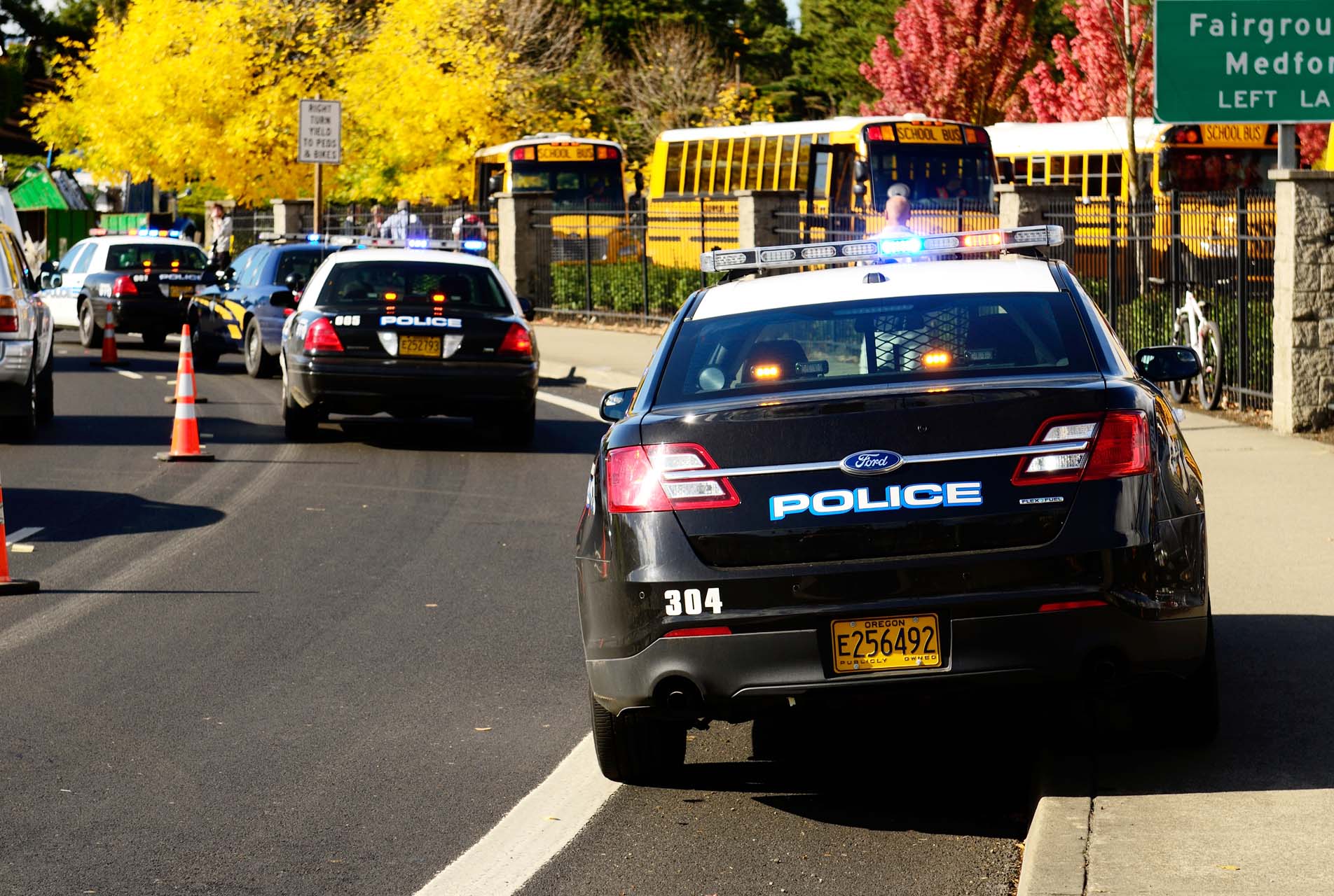 Roseburg Oregon - October 16, 2012: Police cars and school buses at an accident scene at the entrance of the High School loading zone.