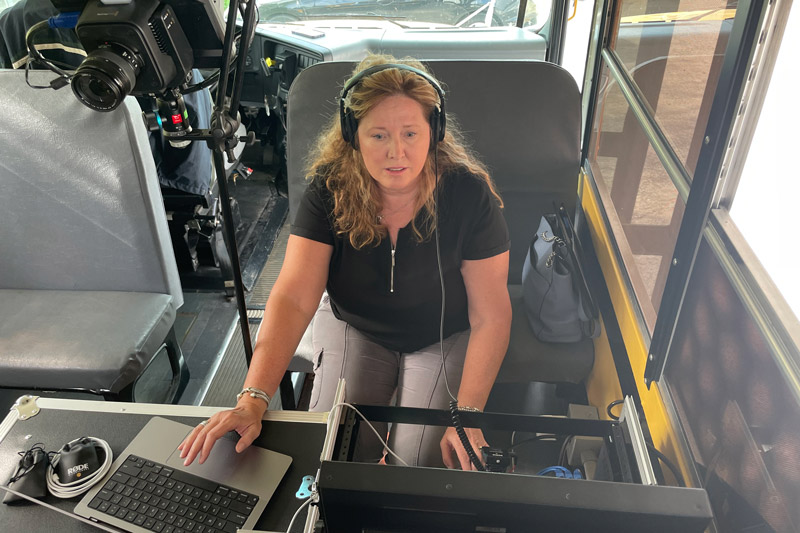 Audrey Fish, the communications manager for AST Partners, works the controls for a podcast recorded on the HEROES Bus to highlight the roles played by company drivers.