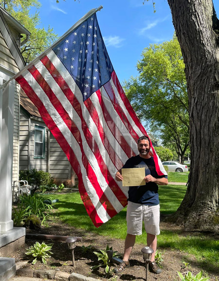 Andrew Gardner, director of marketing for the Gardian Angel system, poses with the U.S. flag received from House Speaker Nancy Pelosi's office.