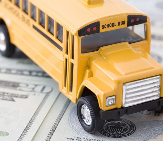 Miniature School Bus on top of Money.