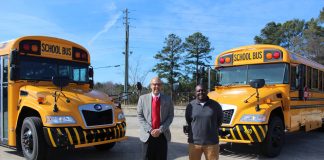 Superintendent Trent North and EW Tolbert, the transportation director, of Douglas County School System in Georgia, pose with school buses. North is a finalist for the 2023 Superintendent of the Year.