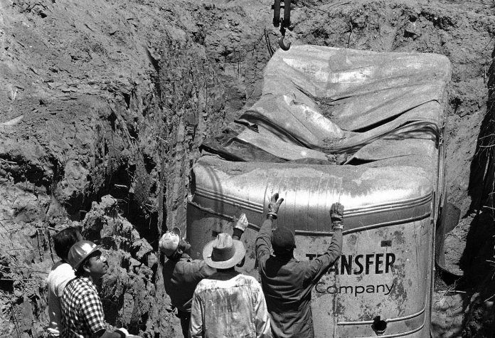 Workmen inspect the van at a rock quarry in Livermore, California, on July 20, 1976. The van contained 26 Chowchilla schoolchildren and their bus driver until they were able to free themselves. (AP Photo/James Palmer)
