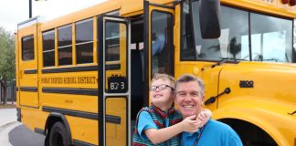 Rick Daynes and son Eli pose outside the school bus. Daynes became a driver for Poway Unified School District near San Diego, California, after experiencing the effects of the driver shortage. (Photo courtesy of Poway Unified School District.)