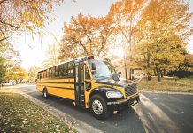 Propane autogas bus driving a school route in the fall.